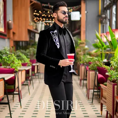 This black velvet blazer is the definition of luxury. It features intricate geometric embroidery on the lapels, creating a look that is both sophisticated and unapologetically modern for any formal event.