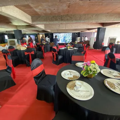 A complete view of a sales exhibition floor we set up for a real estate client. The space is defined by a bold red carpet, with neatly arranged round tables for discussions and a large screen for presentations, ensuring a professional brand experience.