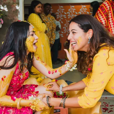A moment of pure joy and mischief during the Haldi ceremony. We love capturing the candid laughter and playful interactions that make this event so special.