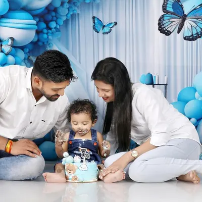 A cake smash is always more fun with family. This shot captures the happy chaos as Naksha explores his first birthday cake with his parents. I love getting these interactive family photos that show the love and connection during the celebration.