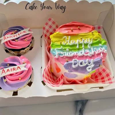 A colorful bento box for Friendship Day. This set includes a mini rainbow cake and two personalized cupcakes, making it a sweet and thoughtful gift for your best friends.