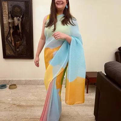 A client looking effortlessly stylish in our multi-color pleated saree. This modern take on a classic garment features beautiful pastel shades, making it a light and happy choice for any event.