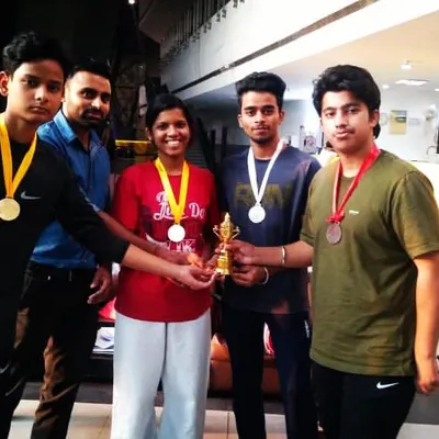 Posing with my students from Team Warriors after a successful competition. They are holding their medals and the team trophy with pride.