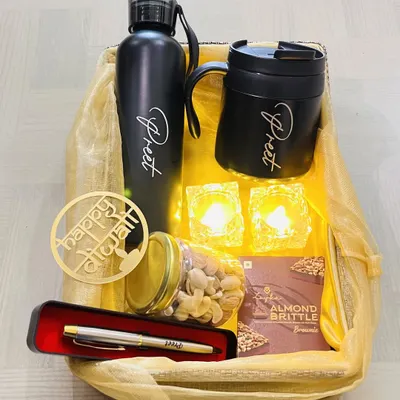 A complete Diwali hamper that blends modern and traditional elements. It includes a personalized bottle and mug, a pen, a jar of dry fruits, and electronic diyas, all beautifully arranged in a gift basket.