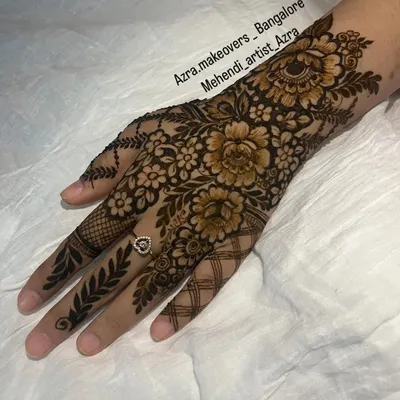 A perfect example of a classic Arabic mehendi design, featuring bold, shaded florals and leafy vines on the back of the hand.