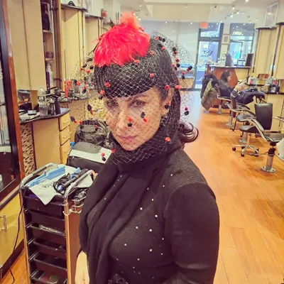 For a themed party, I styled the client's hair to accommodate this dramatic fascinator hat with a net veil. The hair is kept simple with soft waves to let the accessory be the focus.