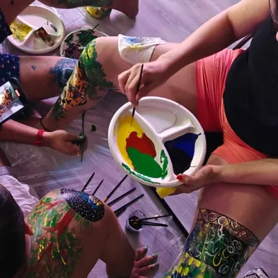 An overhead view of my body painting workshop. I provide all the materials and create a safe, non-judgmental space where participants can explore their creativity on a human canvas.