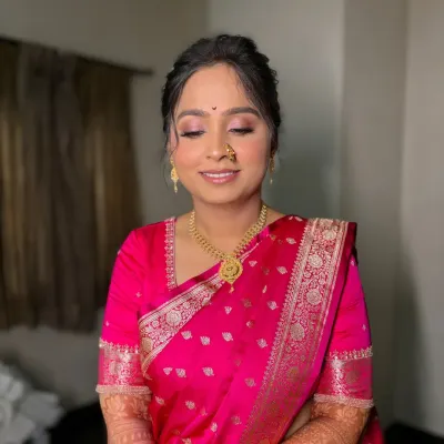 A serene bride on her engagement day. This look features soft pink eyeshadow, a flawless base, and a traditional 'nath', creating a perfect blend of modern and traditional.