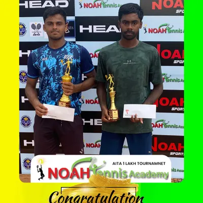 Celebrating the finalists of the AITA 1 Lakh Tournament. Here are winner Dheeraj Kodancha S. and runner-up Kiruthik Kalyaan with their trophies and prize money certificates, standing before the official Noah Tennis Academy backdrop.