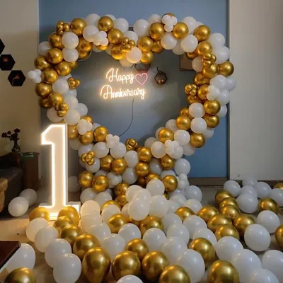Celebrate your first anniversary with this stunning heart-shaped balloon arch in white and gold. The setup is completed with a "Happy Anniversary" neon sign and a large light-up number "1".