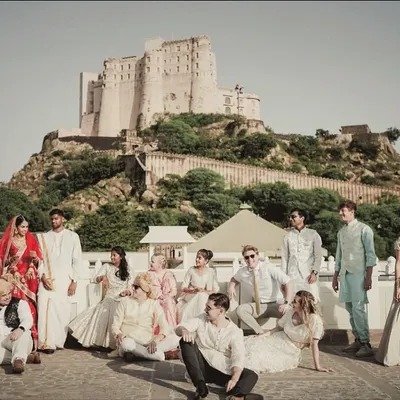 A grand group portrait of the wedding party at Alila Fort Bishangarh. The historic fort provides an epic, larger-than-life backdrop for these unforgettable moments.