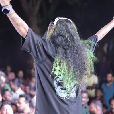 A shot from behind, facing the crowd with my arms raised. This is a moment of pure energy and connection that I live for.