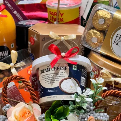A close-up of a bespoke hamper curated for Qatar Airways. This shot highlights the premium products included, such as natural cream cheese and a Pringles Party Stack, demonstrating my ability to cater to luxury corporate clients.