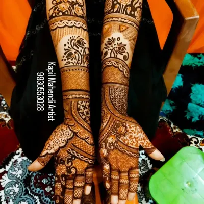 A classic full-hand bridal mehendi with a mix of floral and paisley patterns. The design is dense and intricate, providing a rich and traditional look.