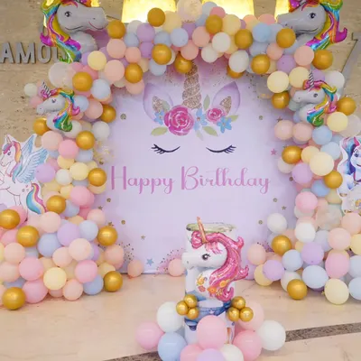 A bright and cheerful unicorn-themed birthday decoration. This setup features a pastel balloon arch, a large unicorn backdrop, and multiple unicorn foil balloons, perfect for a magical celebration.