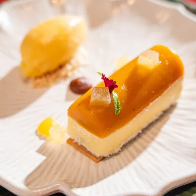 A beautiful yuzu cheesecake dessert. This shot highlights our skill in plating and lighting for delicate and minimalist desserts.