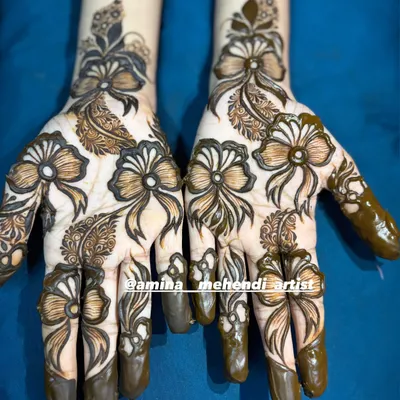A unique and modern mehendi design featuring beautiful, intricate bows as the main pattern on the back of the hands.