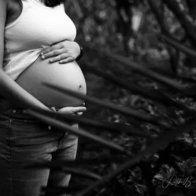 In black and white, the focus shifts to form and emotion. This artistic shot zeroes in on the beautiful curve of the baby bump, a simple and powerful tribute to the life growing within.