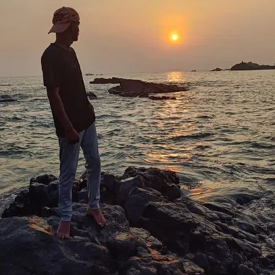 A trekker watching a beautiful sunset over the Arabian Sea. These are the peaceful moments our coastal trek offers.