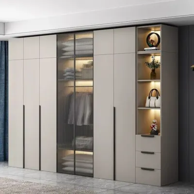 A floor-to-ceiling wardrobe combining closed cabinets with a central fluted glass section. The internal lighting beautifully showcases the contents while maintaining privacy.