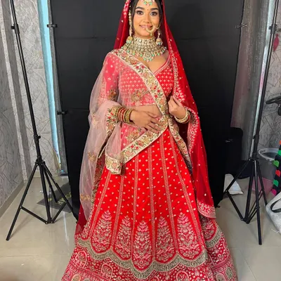 A full view of a classic red bridal lehenga, perfect for the main wedding ceremony. The detailed embroidery along the skirt's border adds a touch of grandeur.