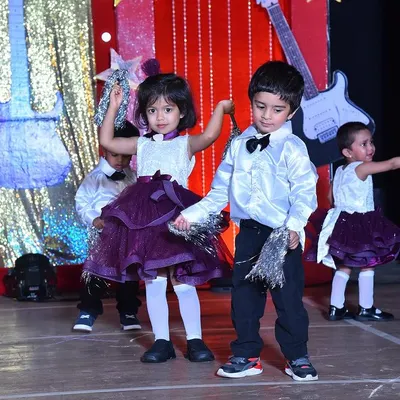 Capturing the fun of a rock-and-roll themed performance, with boys in smart bow ties and girls in stylish purple skirts.