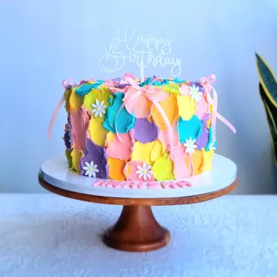 A colorful buttercream cake with a painted, textured effect. I teach how to use a palette knife to apply different colors of buttercream for this artistic, abstract look.