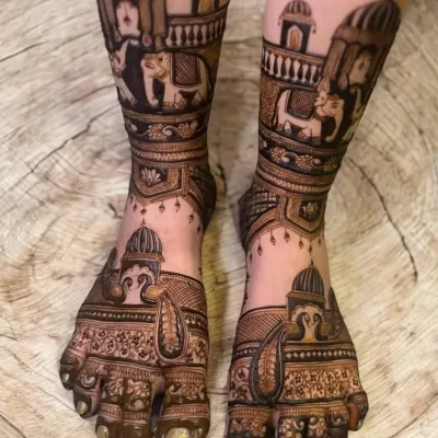 A stunning example of bridal feet mehendi, featuring Rajasthani architecture and elephant motifs that wrap around the ankles.