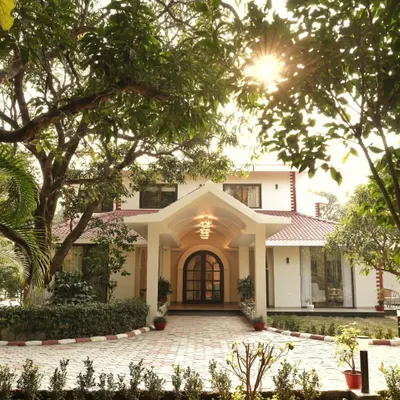 A welcoming arrival at the Doon Homestay, a project where we designed the elevation, interiors, and surrounding landscape. The design uses mature trees and layered shrubbery to frame the entrance, creating a seamless connection between the architecture and the natural beauty of the Dehradun region.