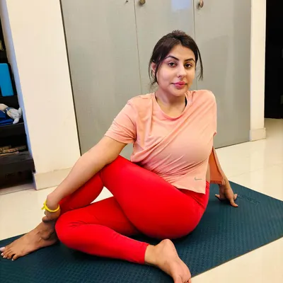 A student holds Ardha Matsyendrasana (Half Lord of the Fishes Pose) during a personal yoga session at her home. This seated twist is excellent for improving spinal mobility, aiding digestion, and calming the nervous system.