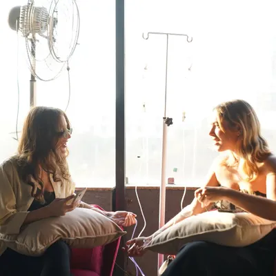 An IV drip session is a perfect time to unwind. Here, clients are seen chatting and relaxing while receiving their treatment in our comfortable clinic space.