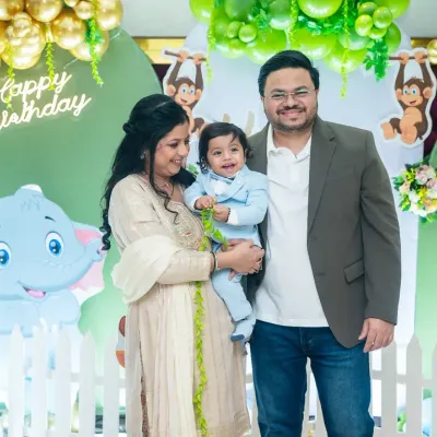 A classic family portrait in front of the birthday decorations. Capturing the whole family together, smiling and happy, is a must-have shot for any first birthday party.