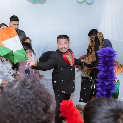 I arrange for top-notch entertainment to keep guests of all ages engaged. Here, a professional magician performs a trick for an amazed audience at a first birthday party.