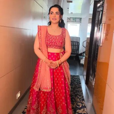 A beautiful bridesmaid in a vibrant pink lehenga. The makeup is fresh and pretty, with a focus on glowing skin and soft pink tones.