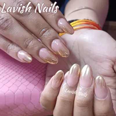A stunning gold chrome ombre on almond-shaped nails, fading from a brilliant metallic into a soft nude base.