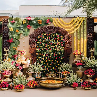The centerpiece of this Haldi ceremony was a stunning antique Prabhavali, which we filled with a dense arrangement of marigolds and greenery. The entire setup is a vibrant celebration of colour and tradition, featuring brass urlis and floral arrangements.