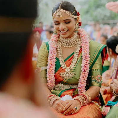The joy of a South Indian wedding ceremony. Meghana’s smile is radiant as she participates in the rituals. Her makeup is traditional, with an emphasis on the eyes and a flawless skin finish.