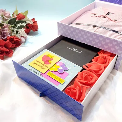 This is my signature 'Shirt Box' hamper, which features a pull-out drawer. The drawer holds a wallet, a mini scrapbook, and some decorative roses, while the top compartment holds a folded shirt.
