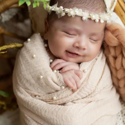 A sweet newborn smile is the most precious thing to capture. This little one is dreaming happy dreams, all wrapped up and cozy.