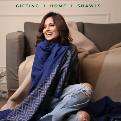 This vibrant royal blue shawl with its modern chevron design embodies contemporary elegance. It demonstrates how our pieces can be both a comfortable wrap for a quiet moment at home and a chic accessory for a day out. The soft texture and rich color make it a standout addition to any wardrobe.