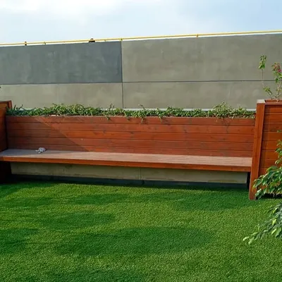 This custom-built wooden bench is designed with planters at each end, seamlessly integrating seating with greenery for a functional and beautiful garden feature.