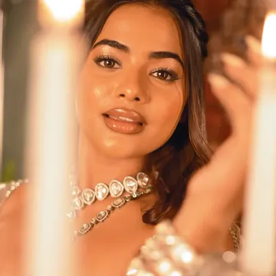 A high-fashion, queenly look from a creative shoot. The focus is on luminous, glass-like skin, a glossy nude lip, and a simple braided hairstyle, creating a look of pure royalty.