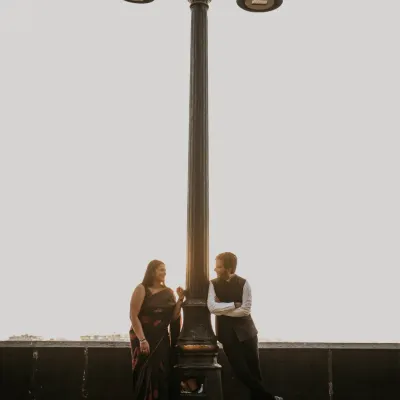 A classic, romantic portrait under a vintage lamppost in Mumbai. This shot captures the timeless charm of the city, creating a quiet, intimate moment against the evening sky.