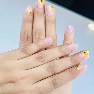 A cheerful sunflower design painted on a soft pink base. This is a perfect way to bring a little bit of sunshine to your manicure.