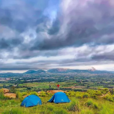 Camping with a view of the rolling landscape near Namma Bengaluru. This spot overlooks the plains and distant hills, including the famous Nandi Hills, offering a sense of scale and freedom.