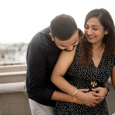 The pure joy of a pregnancy announcement. This candid shot on a rooftop captures the couple's laughter and excitement. These early-stage sessions are all about celebrating the beginning of a new chapter.