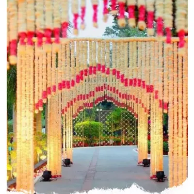 This is a beautiful entrance tunnel I created entirely from fresh flower strings. The mix of white and pink flowers forms an archway that guides guests into the venue with warm lighting.