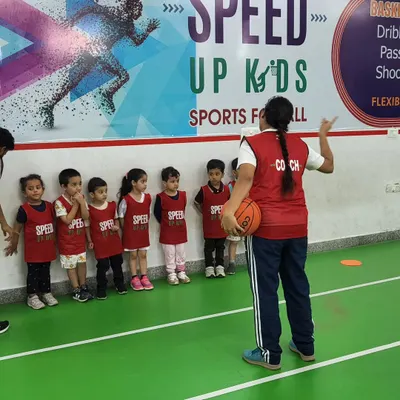 A coach addresses a line of young athletes, explaining the next drill. Clear communication and a structured approach are key to our teaching method.