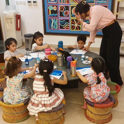 My cutie pie toddlers, busy at work. With focused faces and colorful stools, they are completely absorbed in their painting activity.