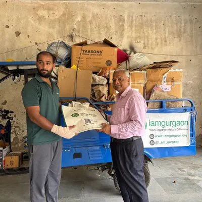 A member of our team receives a bag of sorted dry waste from a resident during a community collection drive. Every contribution, big or small, adds up to a massive collective impact.